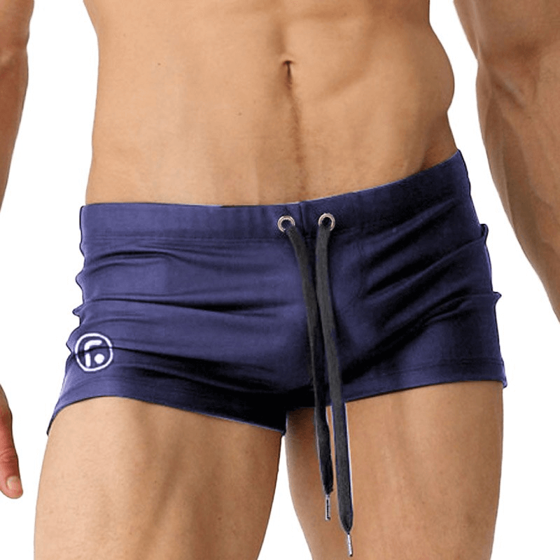 Men's blue drawstring swimming trunks for beach and pool, sexy and comfortable with spandex and nylon blend.